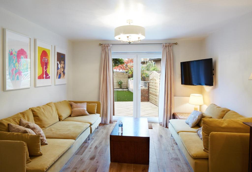 a living room with two couches and a tv at Second Nest Hampton Street in London