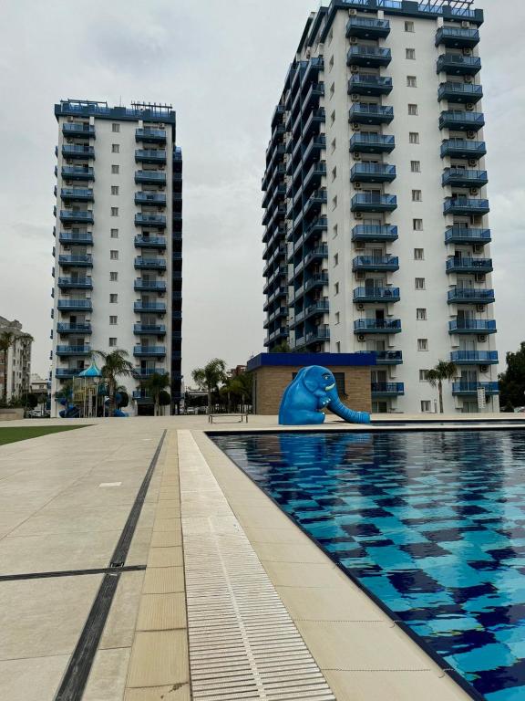 a swimming pool in front of two tall buildings at Royal Life Poseidon Residences Long Beach in Iskele
