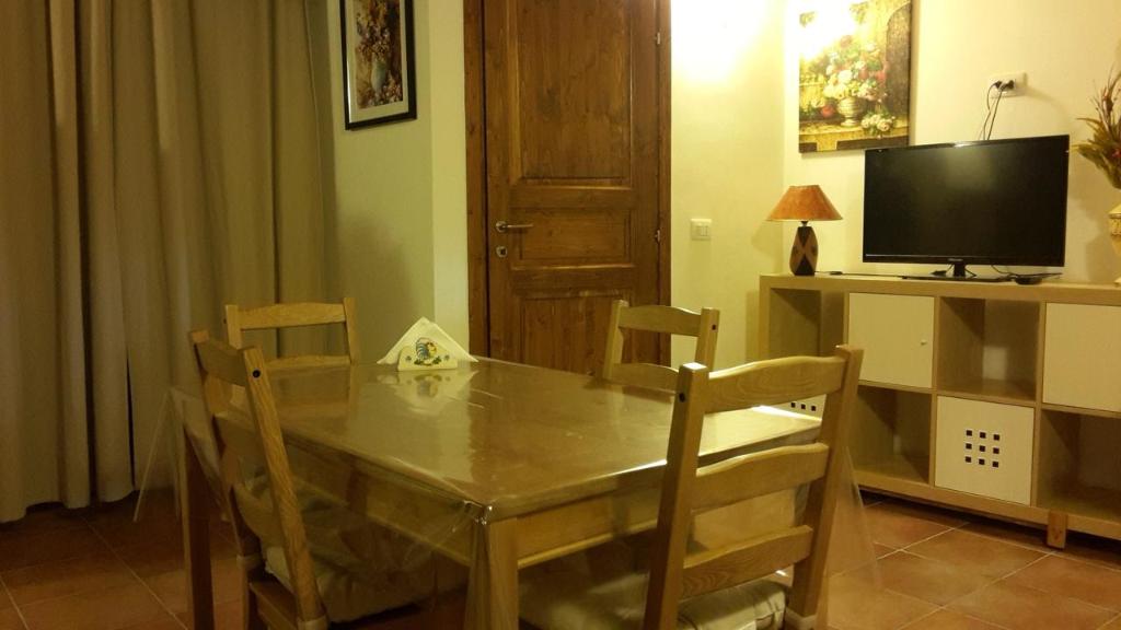 a dining room table with chairs and a television at Nel Vicoletto in Ginosa