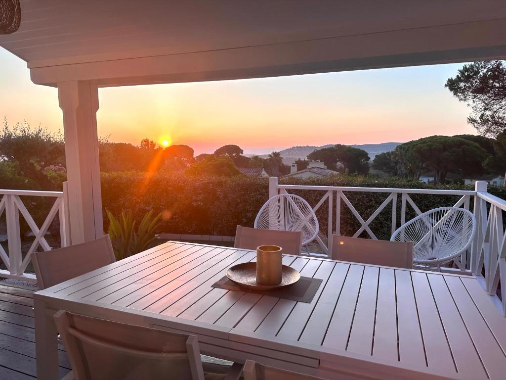 a coffee cup sitting on a wooden table on a porch at Jolie Maison Cosy Vue Golfe de Saint Tropez in Gassin