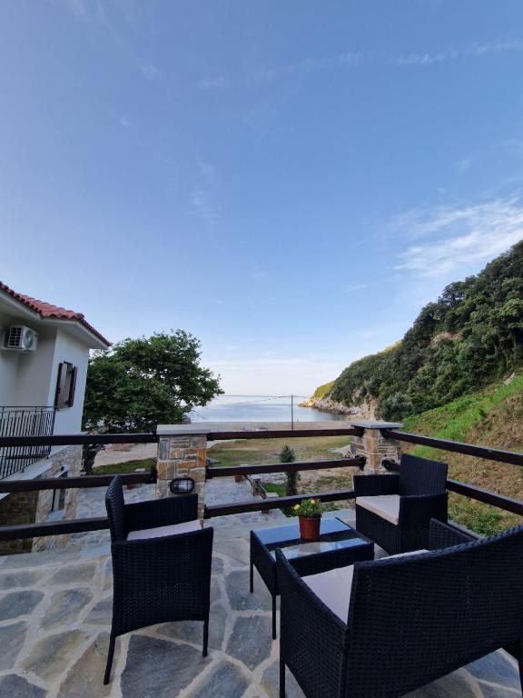 a patio with chairs and a table and a view of the ocean at Limnionas Apartments in Xorychti