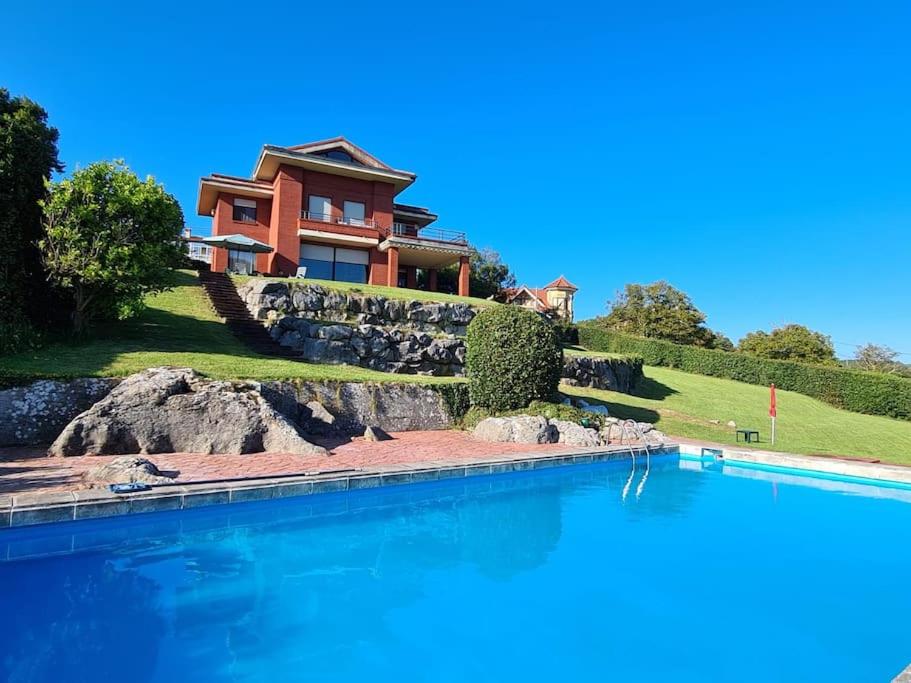 a house with a swimming pool in front of a house at Casa con piscina en Ajo - Las Arrañadas in Bareyo