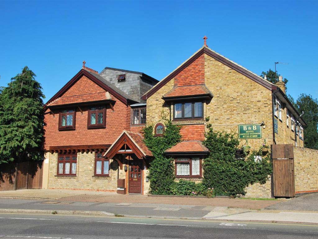 una gran casa de ladrillo en la esquina de una calle en Oakwood Bed and Breakfast Heathrow, en Hillingdon