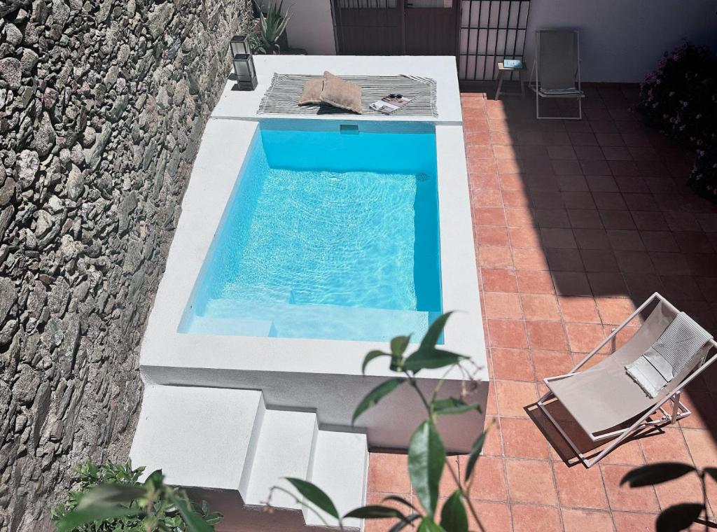 a swimming pool with two chairs and a table at Casa del Aire in Aldea de Trujillo
