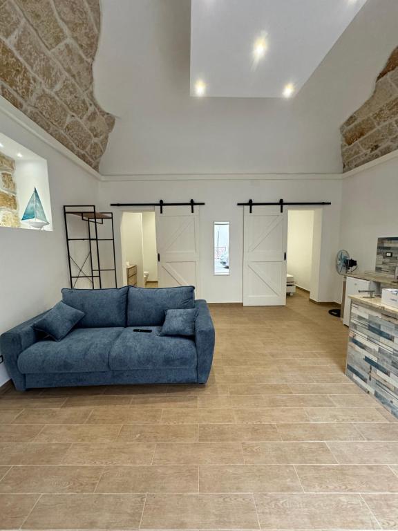 una gran sala de estar con un sofá azul en el centro en Sicilia biedda casa vacanze, en Terrasini