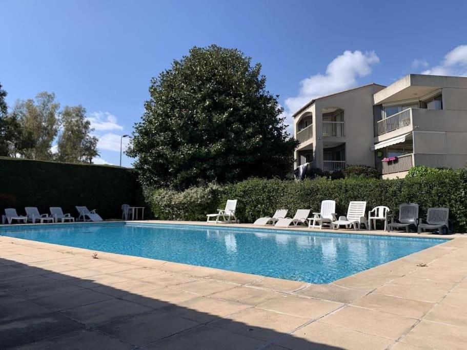 une piscine avec des chaises longues et un bâtiment dans l'établissement 1 Bed Antibes les pins with Pool, à Antibes