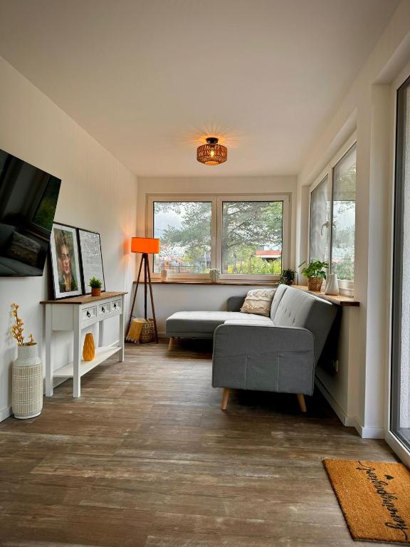 a living room with a couch and a tv at Ganzes Tiny House "Thüringer Ruhe" mit großem Garten nahe Rennsteig in Laucha