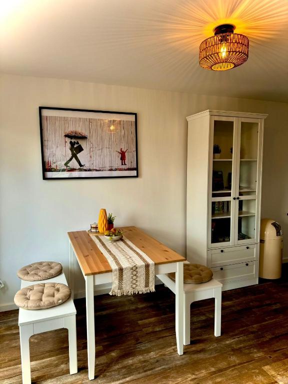 a dining room table and two stools in a room at Ganzes Tiny House "Thüringer Ruhe" mit großem Garten nahe Rennsteig in Laucha