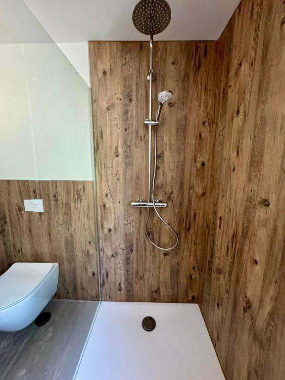 a bathroom with a toilet and a shower with wooden walls at Ganzes Tiny House "Thüringer Ruhe" mit großem Garten nahe Rennsteig in Laucha