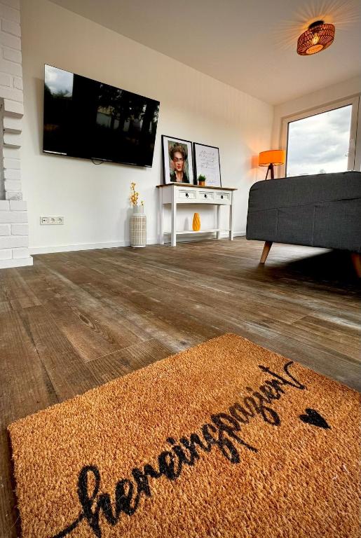 a living room with a television and a rug at Ganzes Tiny House "Thüringer Ruhe" mit großem Garten nahe Rennsteig in Laucha