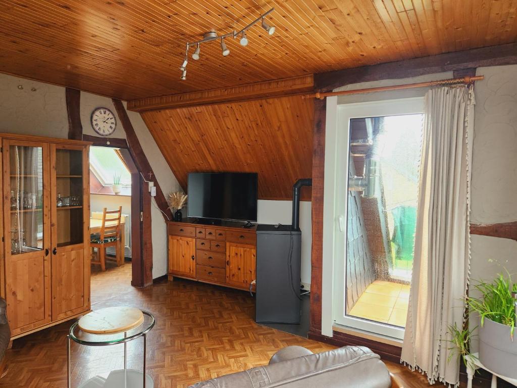 a living room with a tv and a balcony at Appartement Schlanser in Waimes