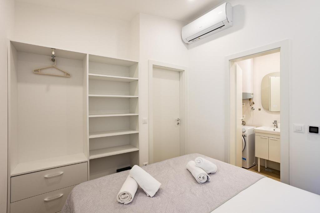 Un dormitorio blanco con una cama y un baño. en Luxury City Center House, en Split