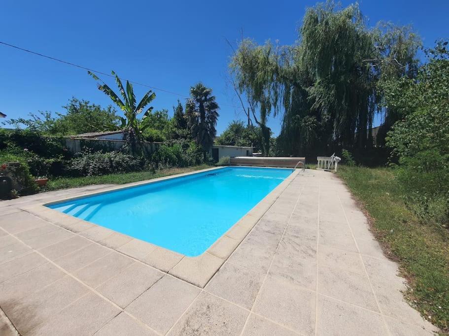 une grande piscine bleue à côté d'un patio dans l'établissement Villa avec piscine chauffée proche Toulouse centre, à LʼUnion