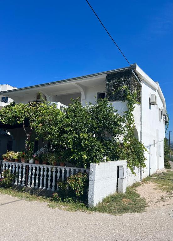 a white house with a fence in front of it at Kastrati Apartments in Ulcinj