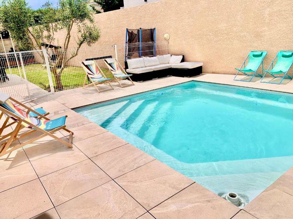 - une piscine avec des chaises et un canapé dans la cour dans l'établissement Villa climatisée de l'Etang de THAU avec piscine, à Sète