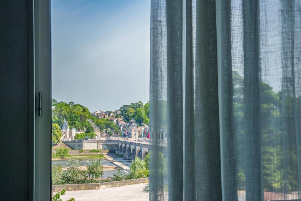 une fenêtre avec vue sur une rivière et un pont dans l'établissement Hyper centre vue bords Loire #confort #luxe, à Tours