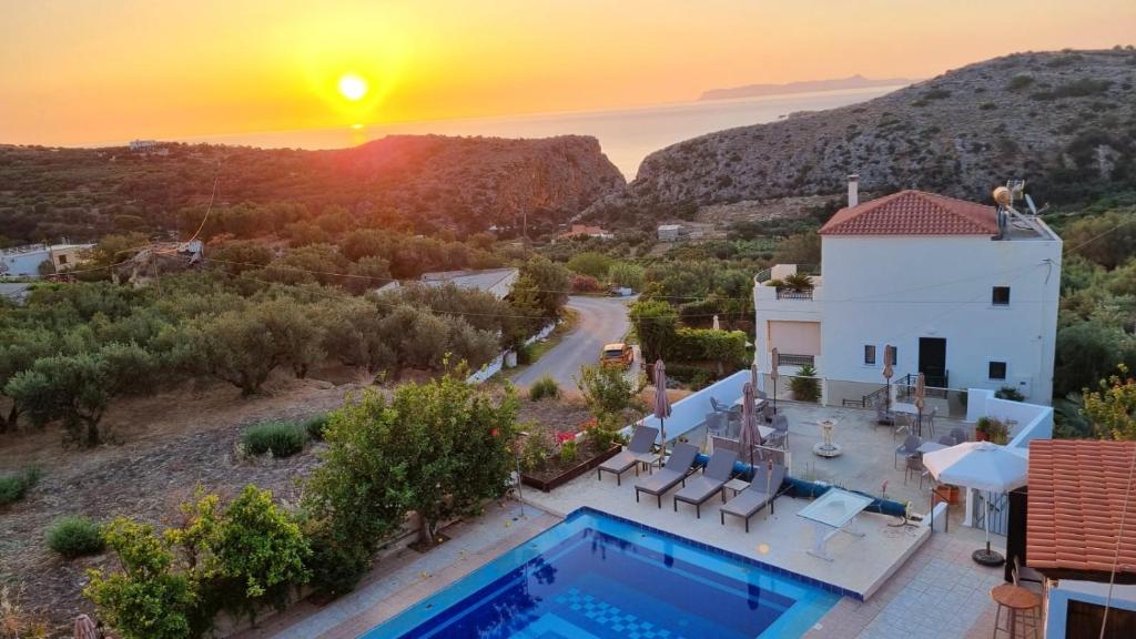 a villa with a swimming pool at sunset at Infinity Wellness Boutique Hotel in Afráta