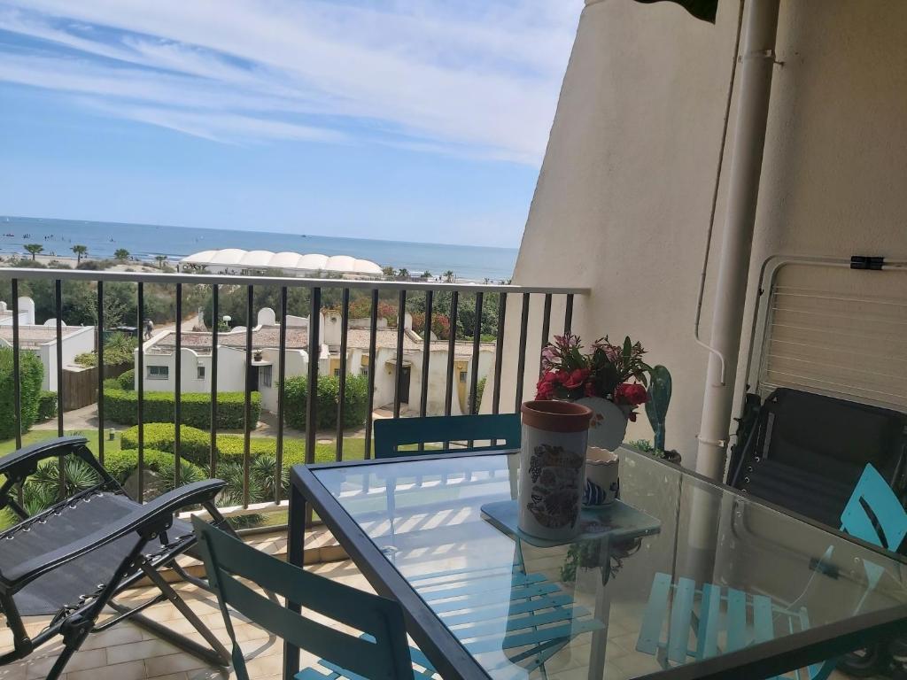 - une table en verre sur un balcon avec vue sur l'océan dans l'établissement Nouveau! Studio avec vue mer exceptionnelle, à La Grande Motte