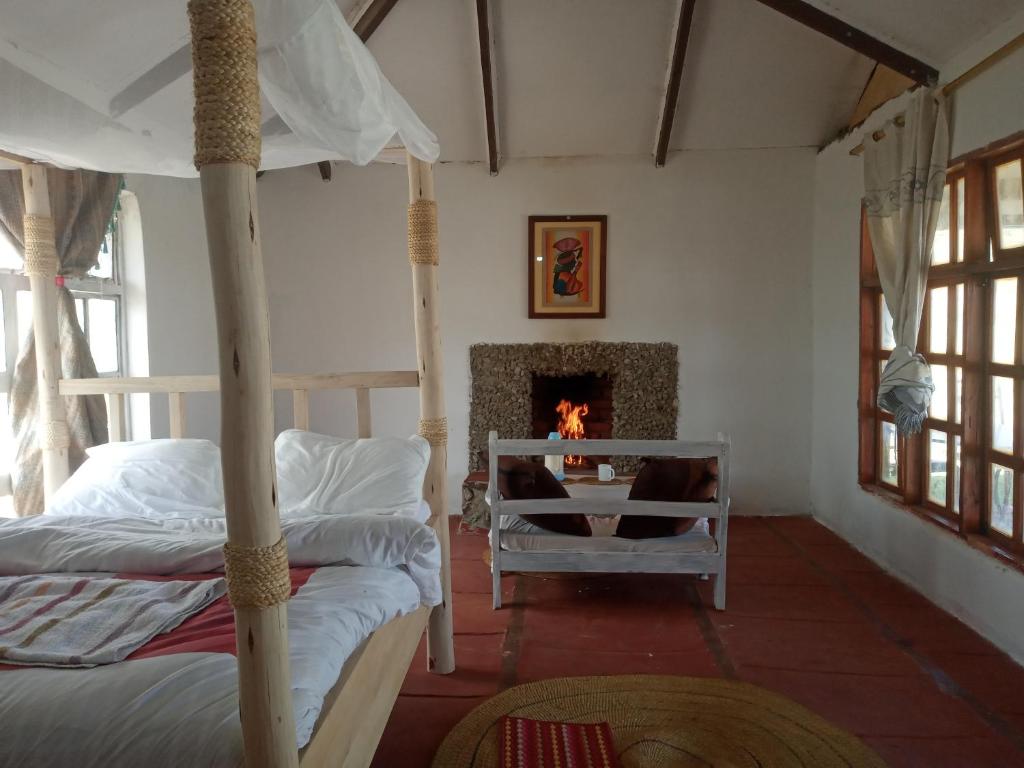 een slaapkamer met 2 stapelbedden en een open haard bij Eco Farm in Karatu