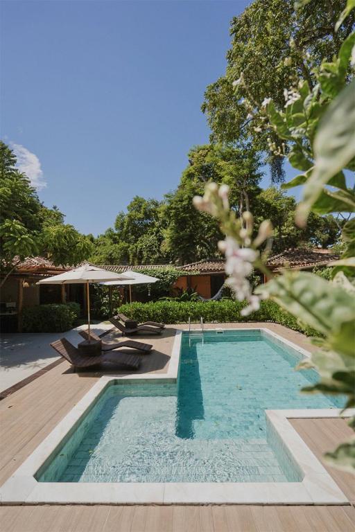 a swimming pool in front of a house at Estalagem D'Ajuda in Arraial d'Ajuda