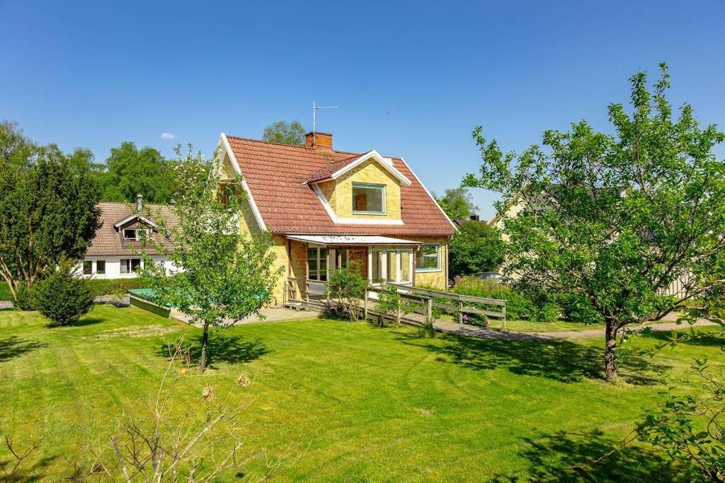 a house with a yard with a fence and trees at Villa Talavidsgatan 15 Rydaholm in Rydaholm