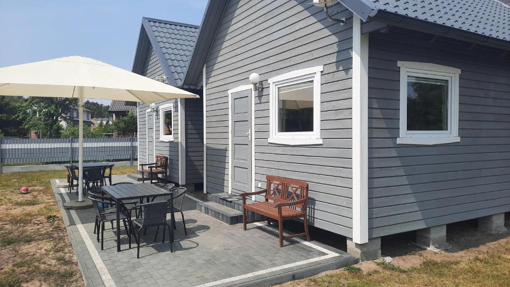 a patio with a table and chairs and an umbrella at Domek nad morzem 79 in Stegna