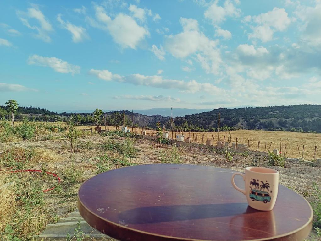 a coffee cup sitting on a table in a field at Kuzine Garden in Pamukkale