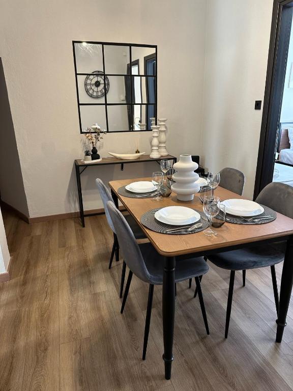 a dining room table with chairs and a mirror at KONAR Guest House in Alexandroupoli