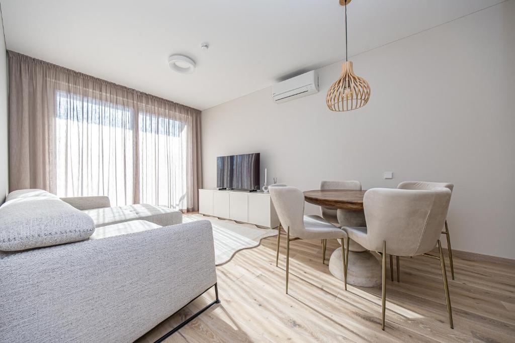 a living room with a table and a couch at Vanagupės Perlas in Palanga