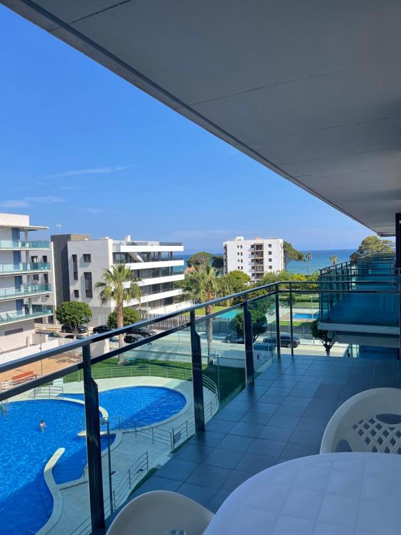 a balcony with a view of a swimming pool and the ocean at Apartamento Augusta Cambrils Lux con vista al mar in Cambrils