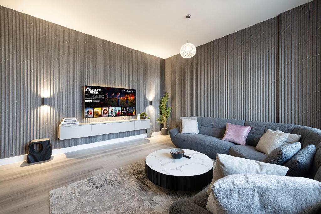 シャルジャにある2Bedroom Apartment - Uptown Al Zahia, Sharjah - Stone Houseのソファとテレビのあるリビングルーム