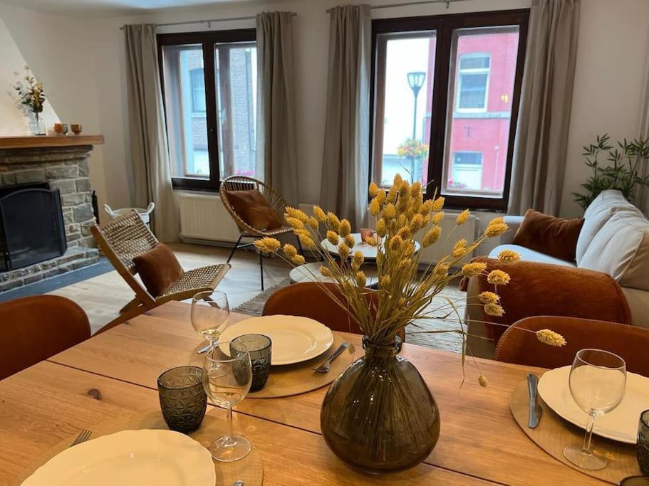 a living room with a wooden table with a vase of flowers at Cielle sous Roche in La-Roche-en-Ardenne