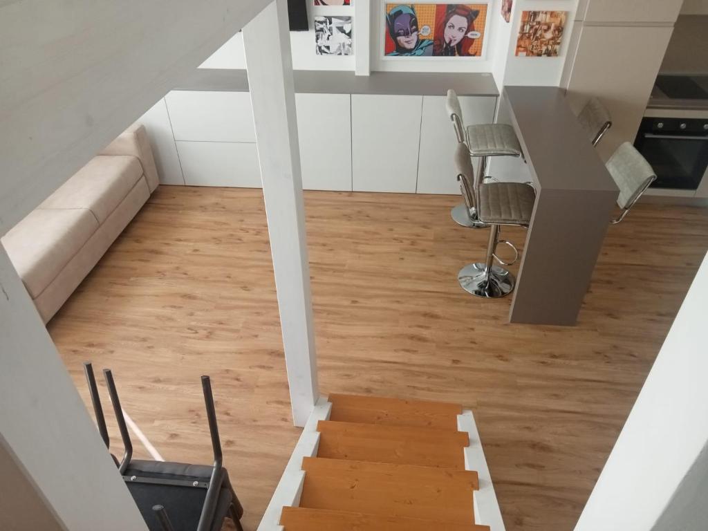 un escalier menant à un salon avec parquet dans l'établissement ARThome Holiday Apartment, à Pescara