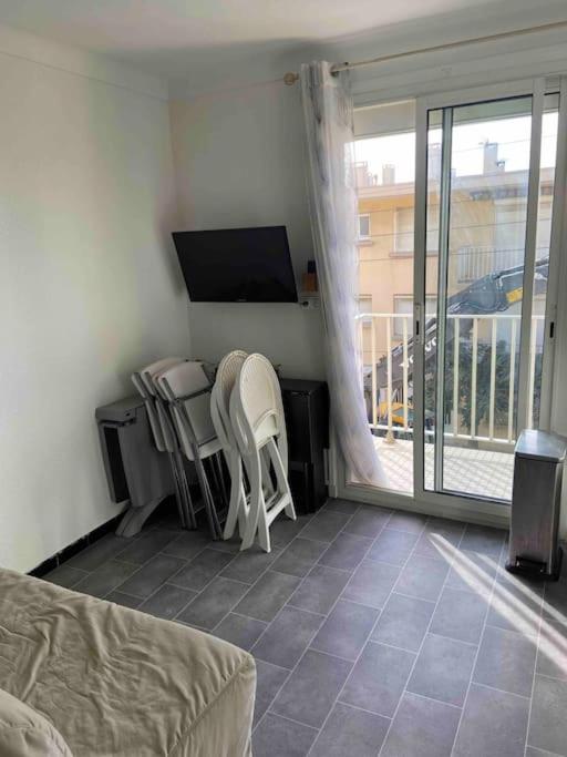 un salon avec une télévision, une table et des chaises dans l'établissement Appartement T2 proche mer, à Canet