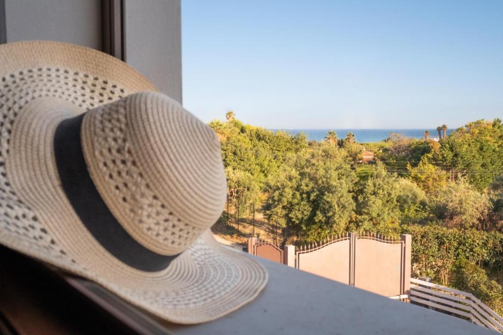 a straw hat is sitting on a window sill at Ca' Libellula Casa Vacanza in Avola