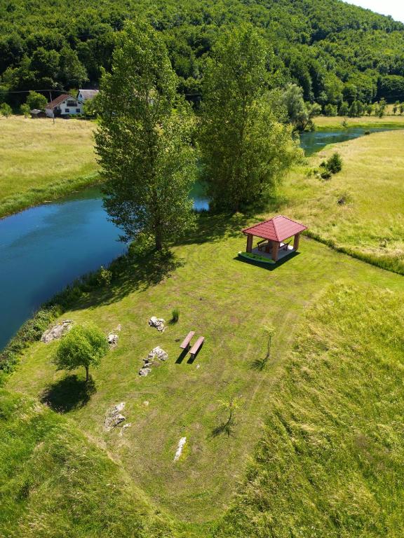 an aerial view of a field with a gazebo next to a river at Apartments River in Otočac