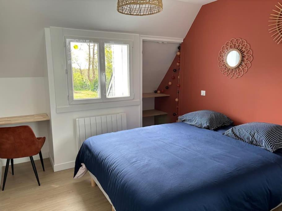 ein Schlafzimmer mit einem blauen Bett und einem Fenster in der Unterkunft Jolie maison proche plages et golf in Bénodet