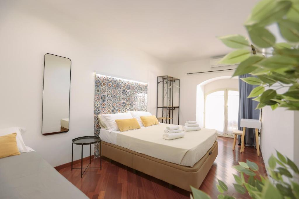 una piccola camera da letto con un letto e uno specchio di DOMUS Gallery a Napoli