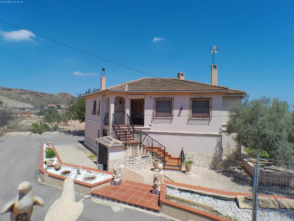 a white house with a staircase in front of it at Chalet con piscina Umut Homes in Alicante