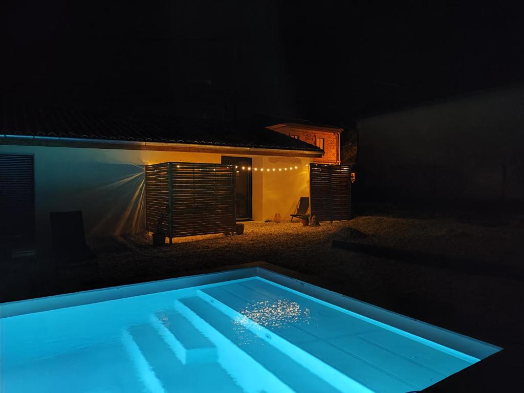 a swimming pool at night with a house at Maison Juliette in Loupiac-de-Cadillac