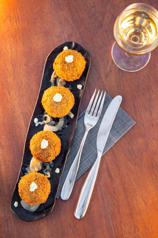 a plate of food on a table with a fork and knife at Hotel Boutique Ses Pitreras in San Antonio Bay