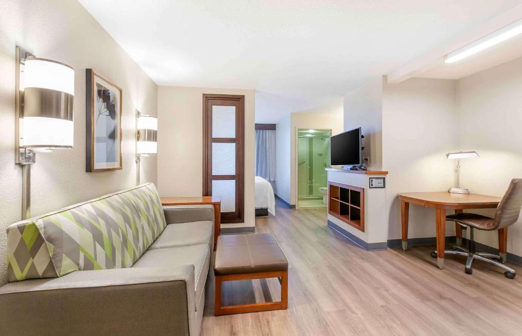 a living room with a couch and a desk with a television at Extended Stay America Premier Suites - Pittsburgh - Cranberry Township - I-76 in Cranberry Township