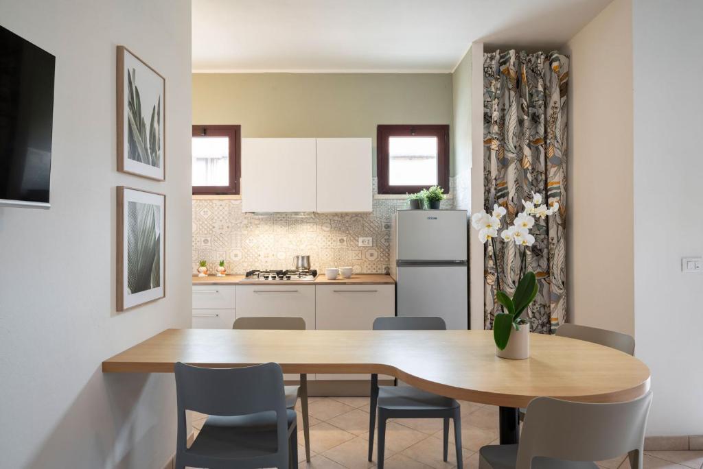a kitchen with a table and chairs and a refrigerator at Le Case di Salvia in San Vincenzo