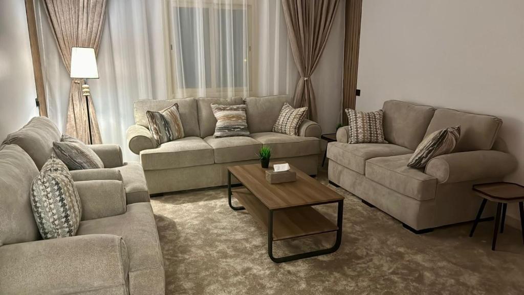 a living room with two couches and a coffee table at شقة فندقيه Happy Season in Hajlah