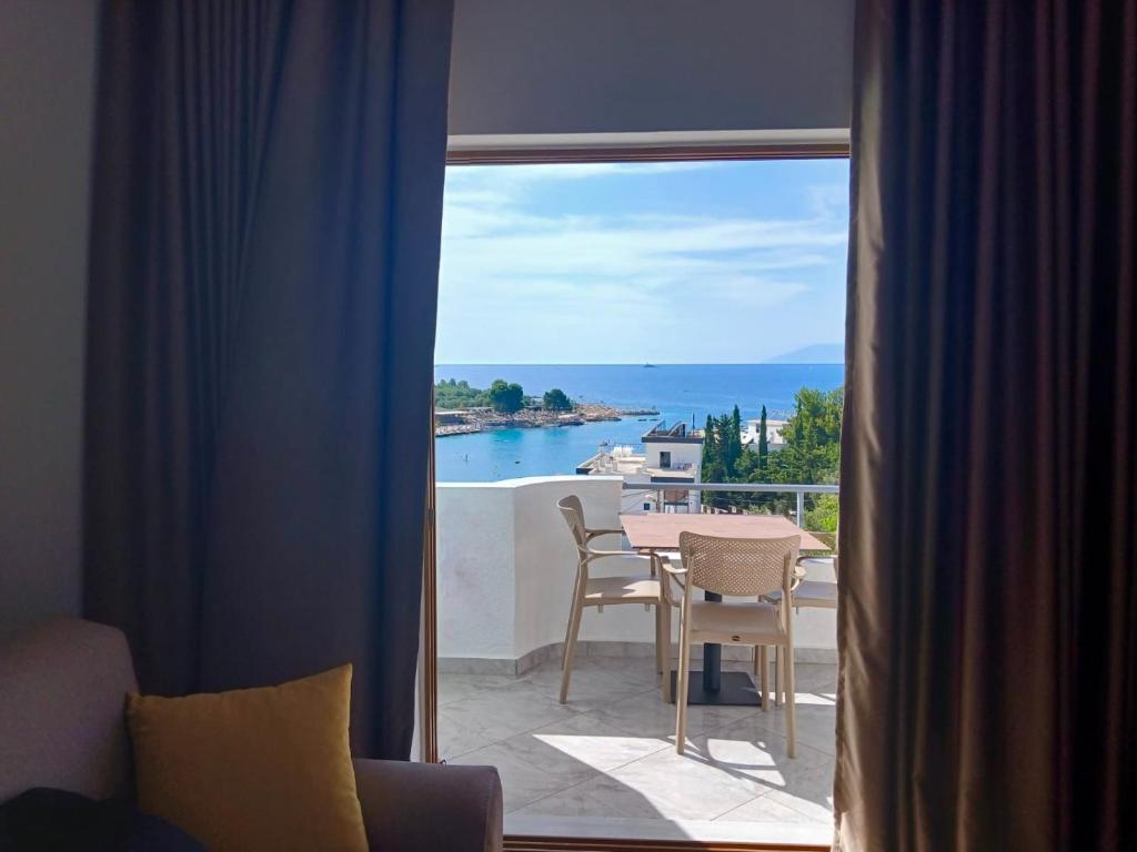 a room with a view of the ocean through a window at Dine Hotel in Ksamil