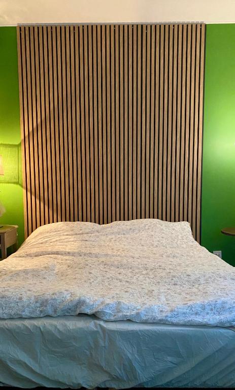 Ce lit se trouve dans une chambre dotée d'un mur vert. dans l'établissement 200 from Martines and Boulevard de la Croisette, à Cannes