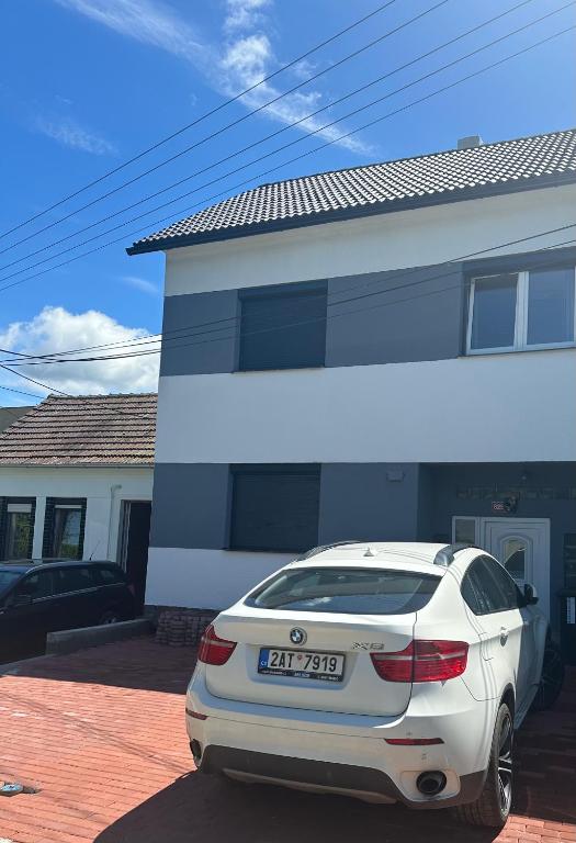 a white car parked in front of a house at Ubytování U Dědy in Moravská Nová Ves