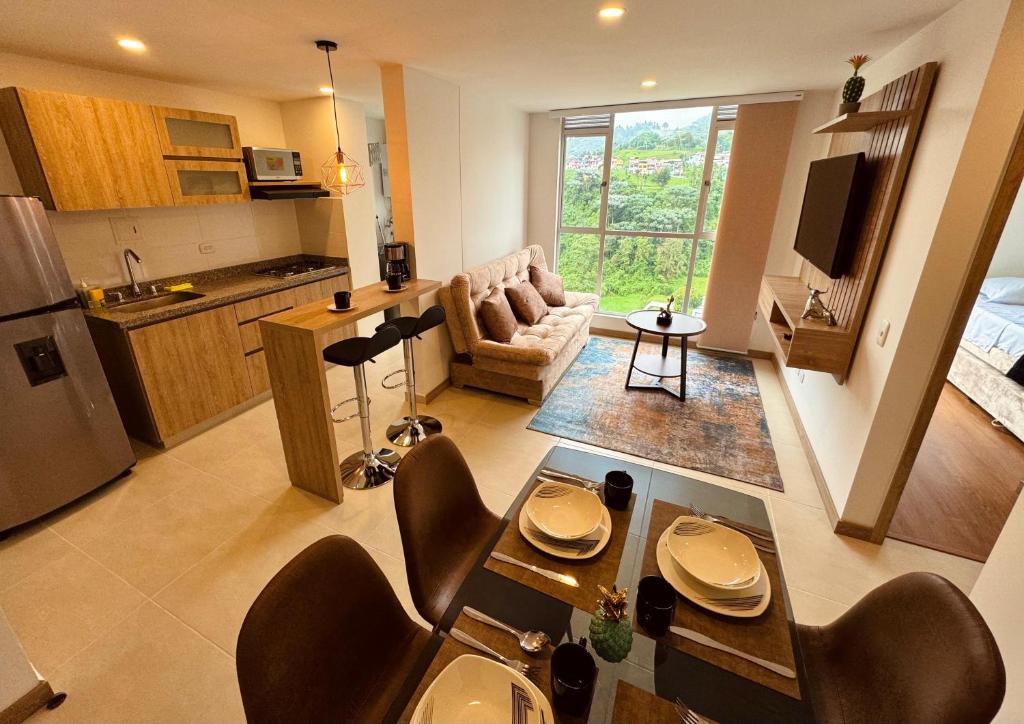 a kitchen and living room with a table and chairs at Espectacular vista, apto de lujo, piscina, gym in Manizales