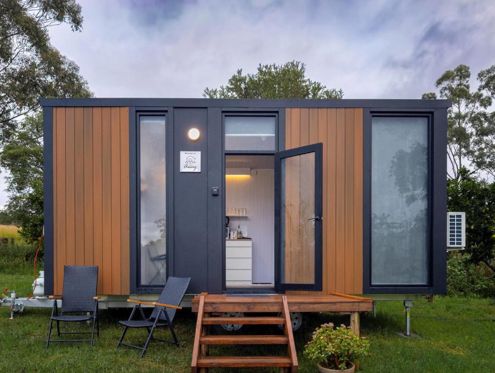 a black and orange tiny house with a table and chairs at The Fog Getaway by Tiny Away in Boolambayte