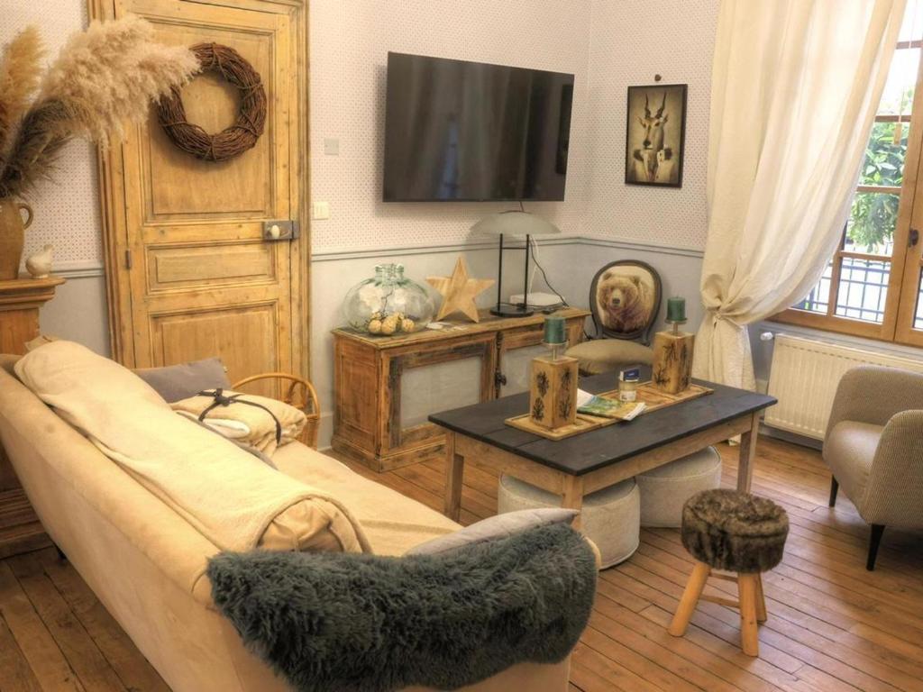 a living room with a couch and a table at Maison de Charme avec Terrasse et Animaux Acceptés à Moulins - FR-1-489-532 in Moulins